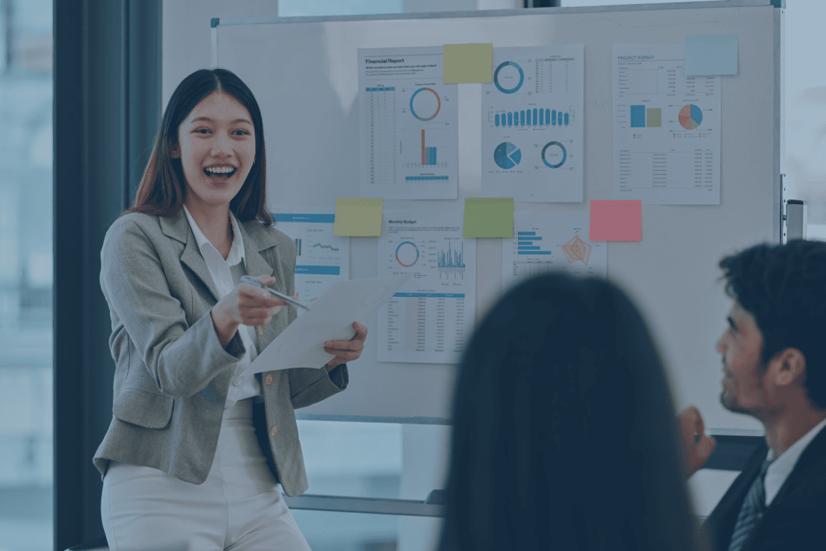 A smilling lady next to a whiteboard with a lot of notes